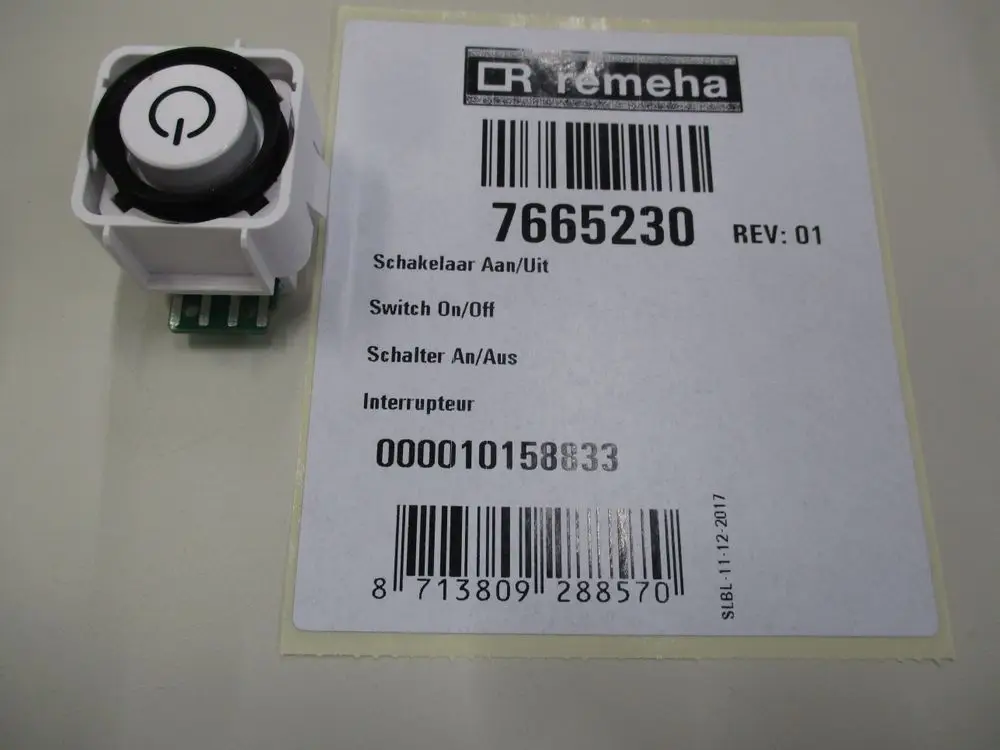 Netzschalter der Marke Remeha in Weiß, mit einem runden Druckknopf und fünf Kontaktpins auf der Rückseite. Das Etikett weist die Artikelnummer 7665230 aus.